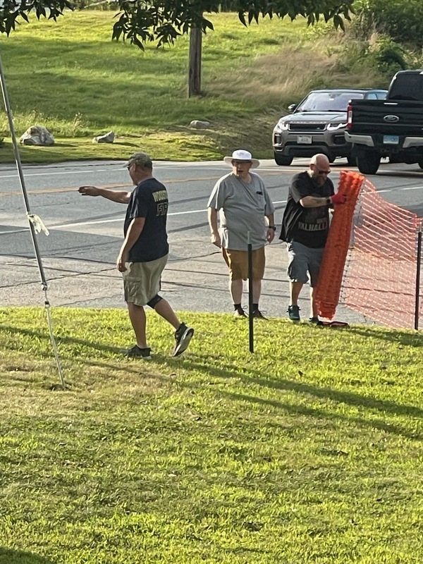 three brothers installing orange fence around the lot.